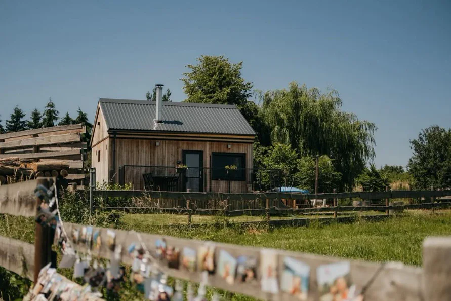 Dřevěný domeček Na paloučku s terasou, za plotem louka a stromy
